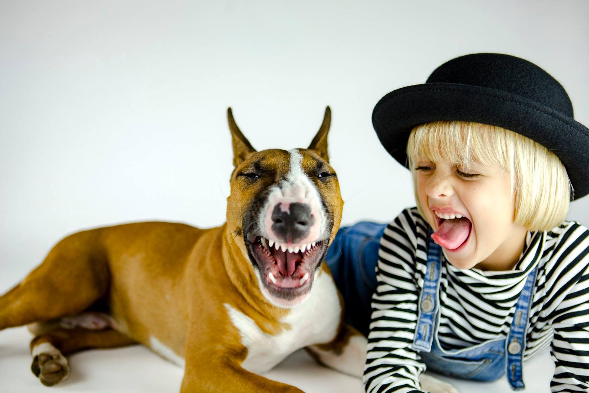 Little girl and her dog both stick their tongues out