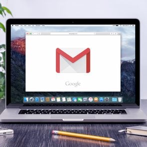Google Gmail logo on the Apple MacBook Pro display that is on office desk workplace