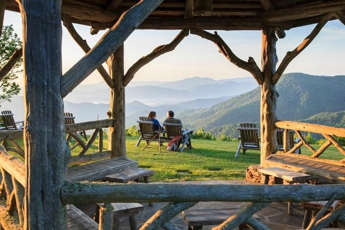 two people sitting in a chairs with a view of the mountains