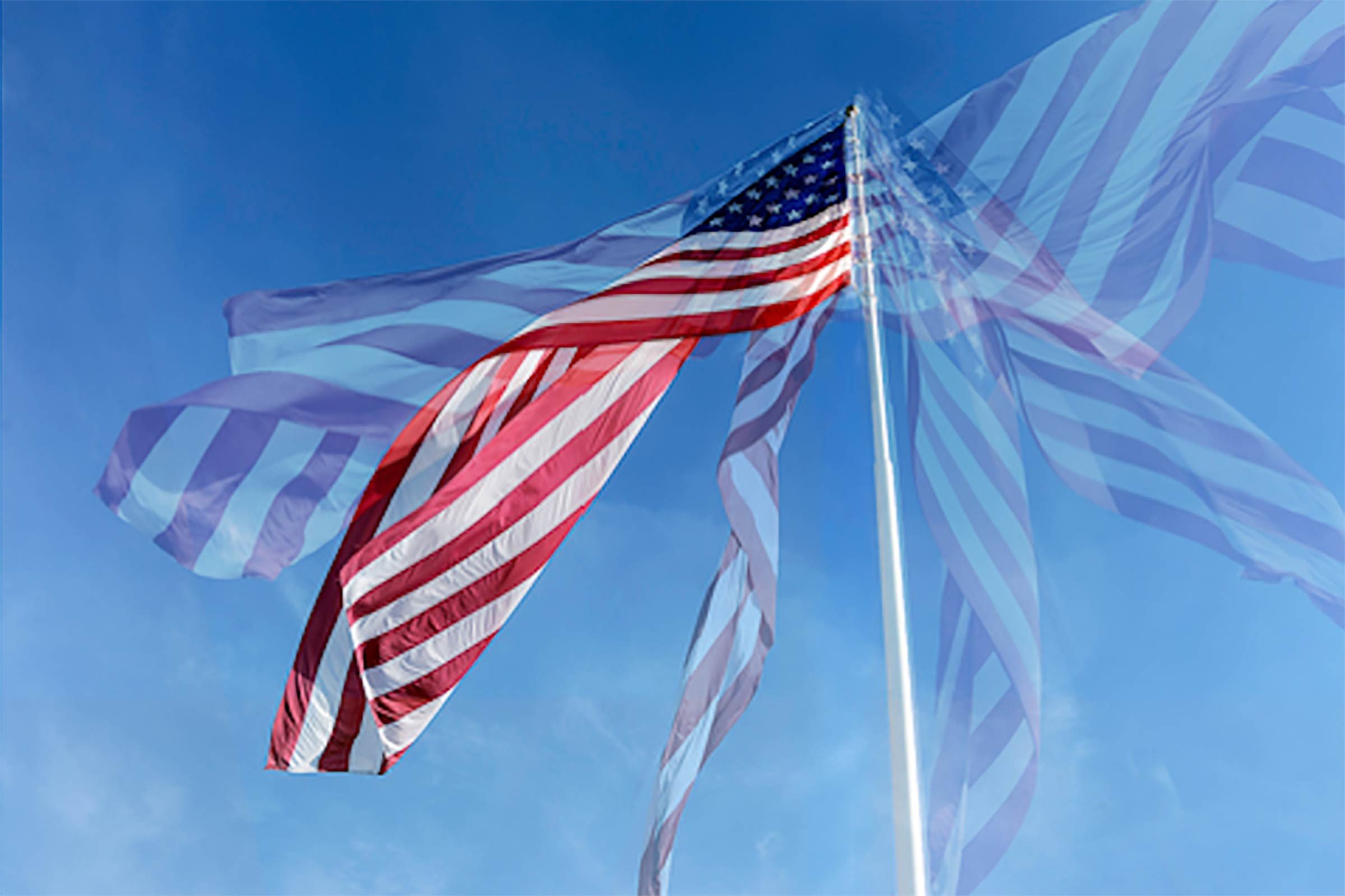 a multiple exposure image of an american flag waving against a blue sky