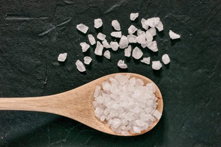 coarse sea salt on dark background close up. Copy space. Flat lay or top view