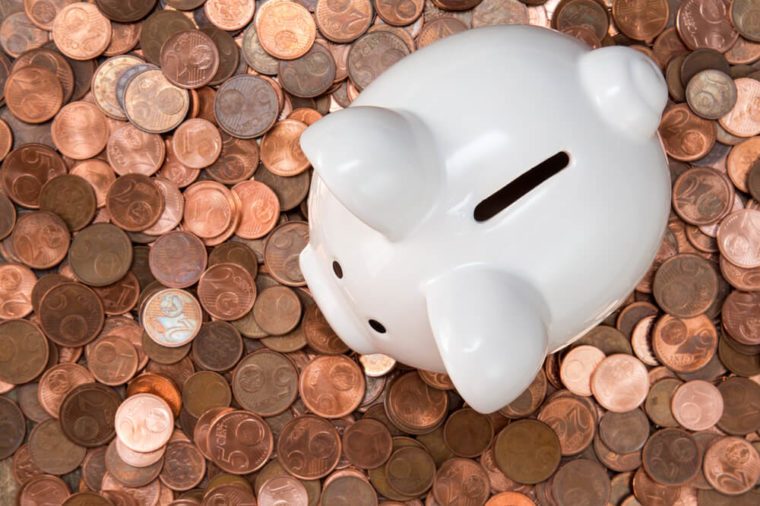 Piggy bank on pile of copper coins (Euro cents).Top view.