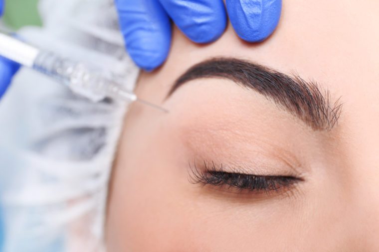 Young woman receiving plastic surgery injection on her face, closeup