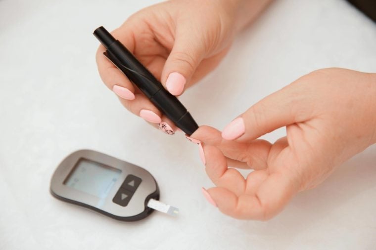 Glucometer. Woman checks blood sugar level for diabetes, insulin levels