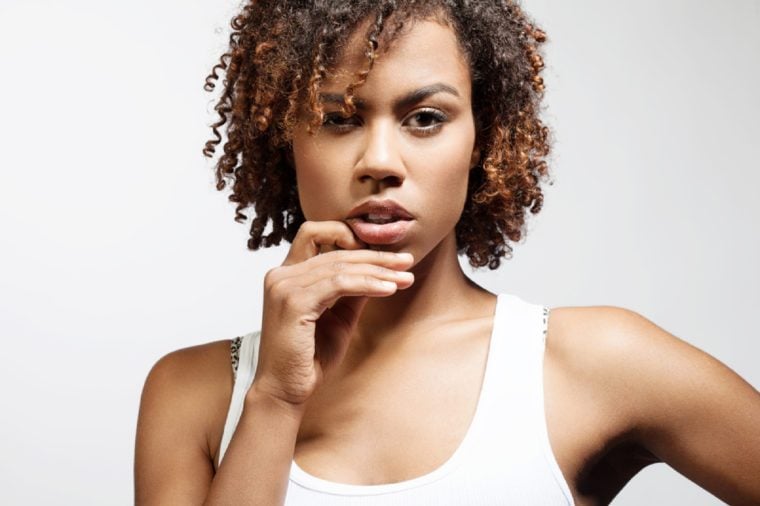 Thoughtful young black woman with clean healthy skin on a white background