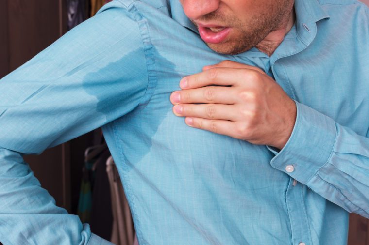 Young man in horror looking at the sweaty shirt