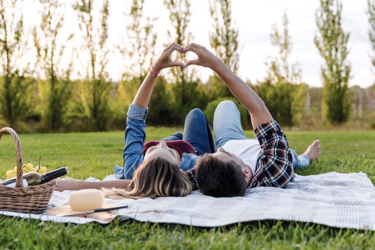 Happy couple in love, lying on the park and enjoying the day together