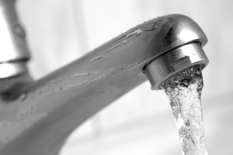 Water tap with flowing water. Selective focus, shallow depth of field