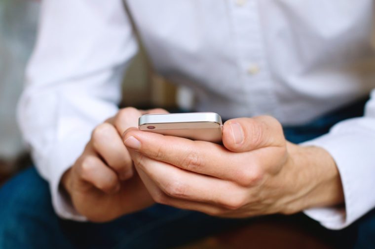 Close up of business man using mobile smart phone