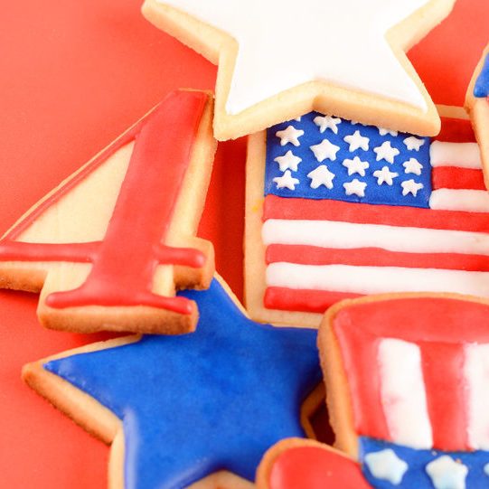 Patriotic cookies for 4th of July on red background. Independence day concept