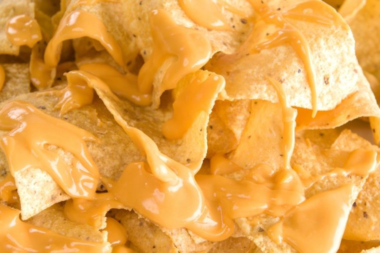 Close-up of yellow tortilla chips covered in nacho cheese