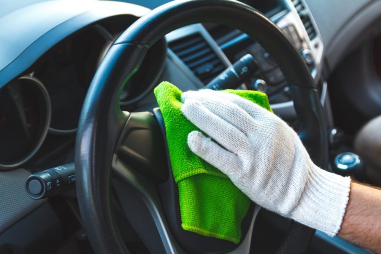 Man wearing gloves to clean the dashboard of the car. Auto Service.