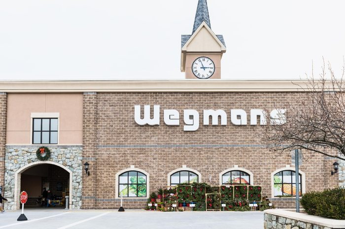 Fairfax, USA - November 30, 2016: Wegmans grocery store facade and sign with people and Christmas wreath decorations