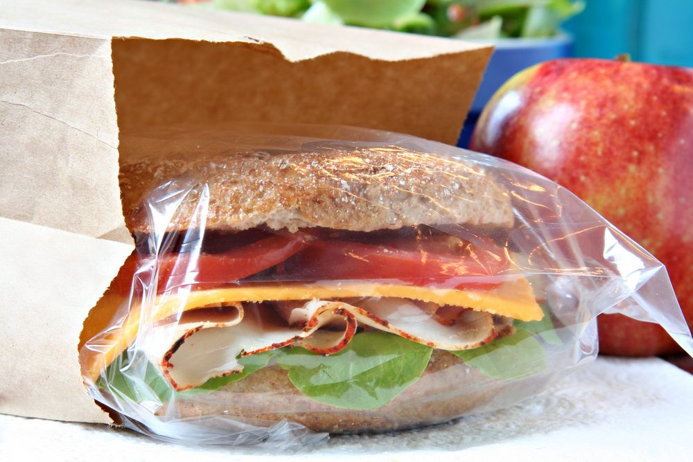 Whole grain sandwich in a brown paper lunch bag.