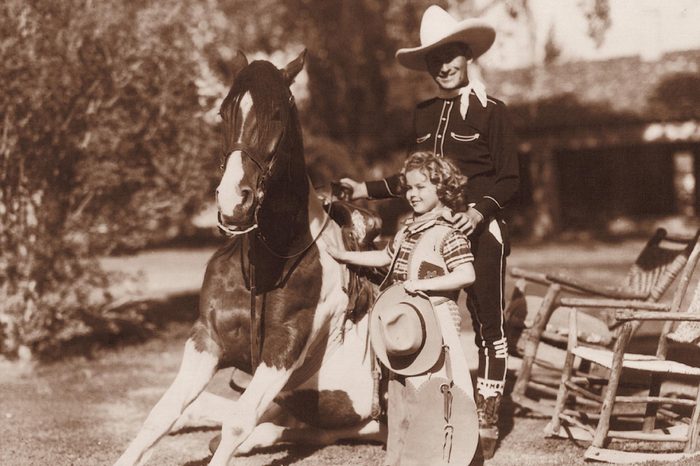 Hollywood cowgirl Shirley Temple with Monty Montana, c. 1938, movie star Shirley Temple and roping celebrity Monty Montana gave a short roping performance at a Western theme party at the Desert Inn in Palm Springs, California in 1938
