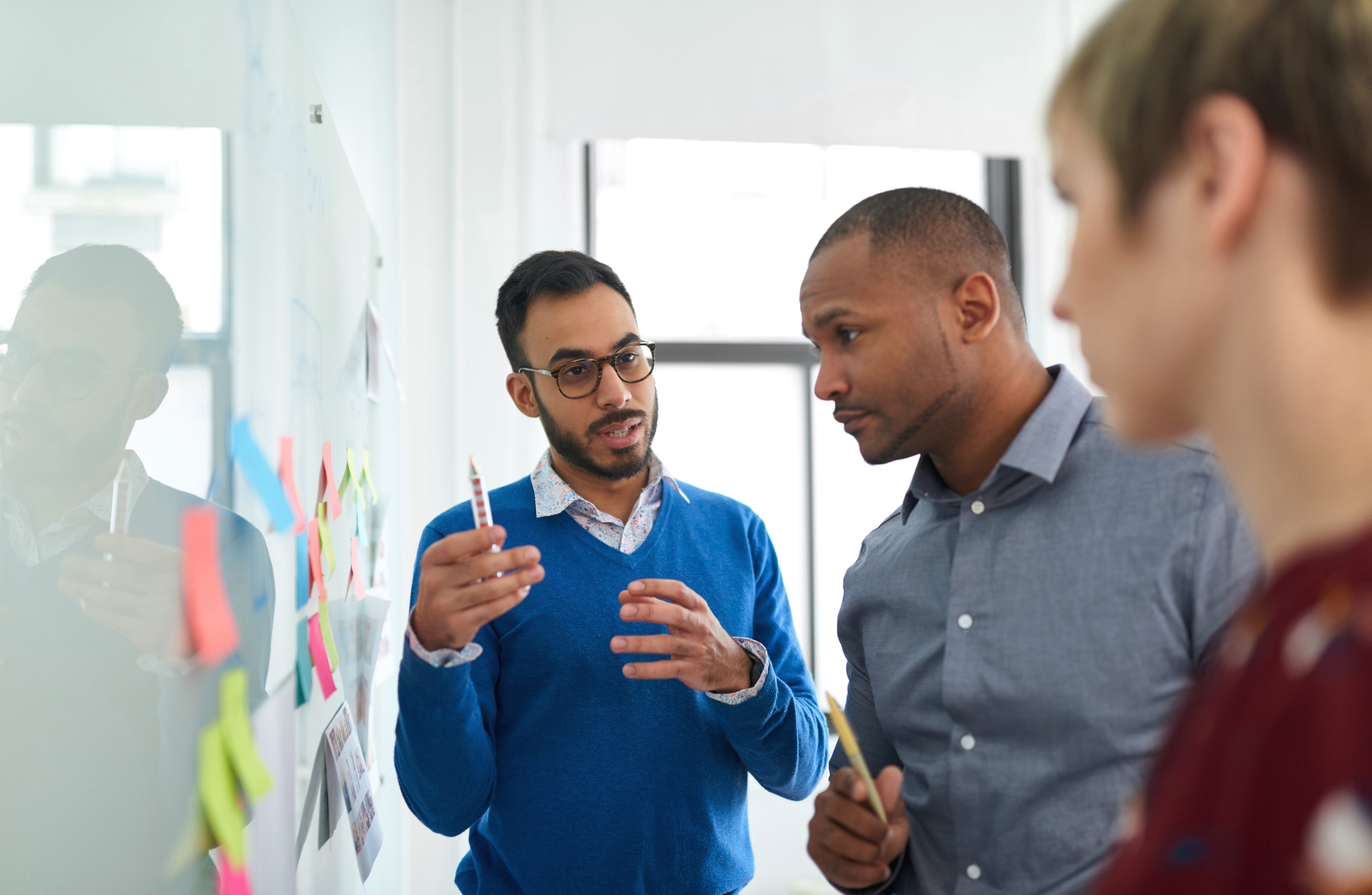 Multi-ethnic group hipster trendy business people discussing during a brainstorm session for their small company