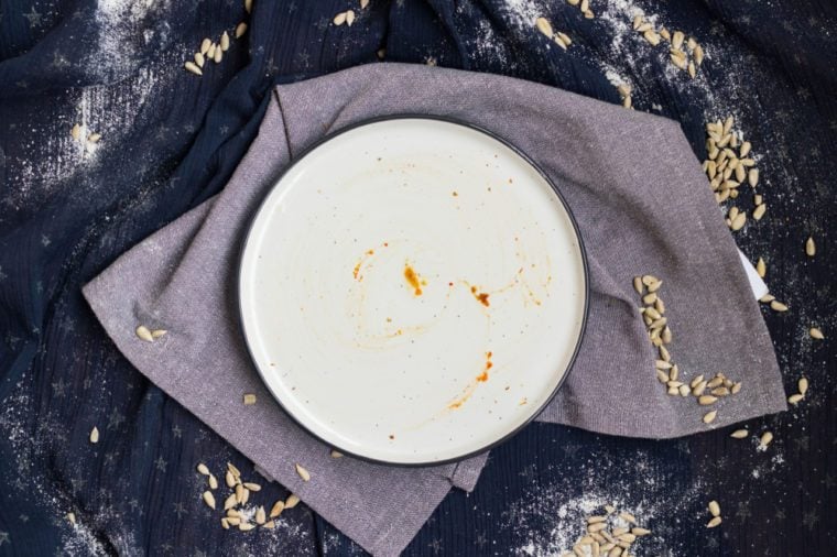 Dissolved dirty and empty, plate left after breakfast, lunch or dinner. Plate with pieces of crumbs and pieces. Kitchenware concept for restaurants and cafes.