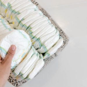 Stack of baby disposable diapers and Pacifier over white background; Shutterstock ID 650657350