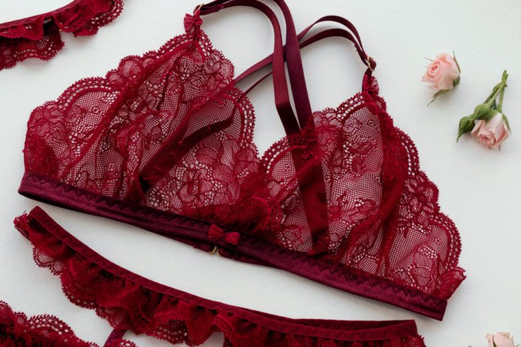 Gift for girl on Valentine's Day. Red lacy lingerie on white background.