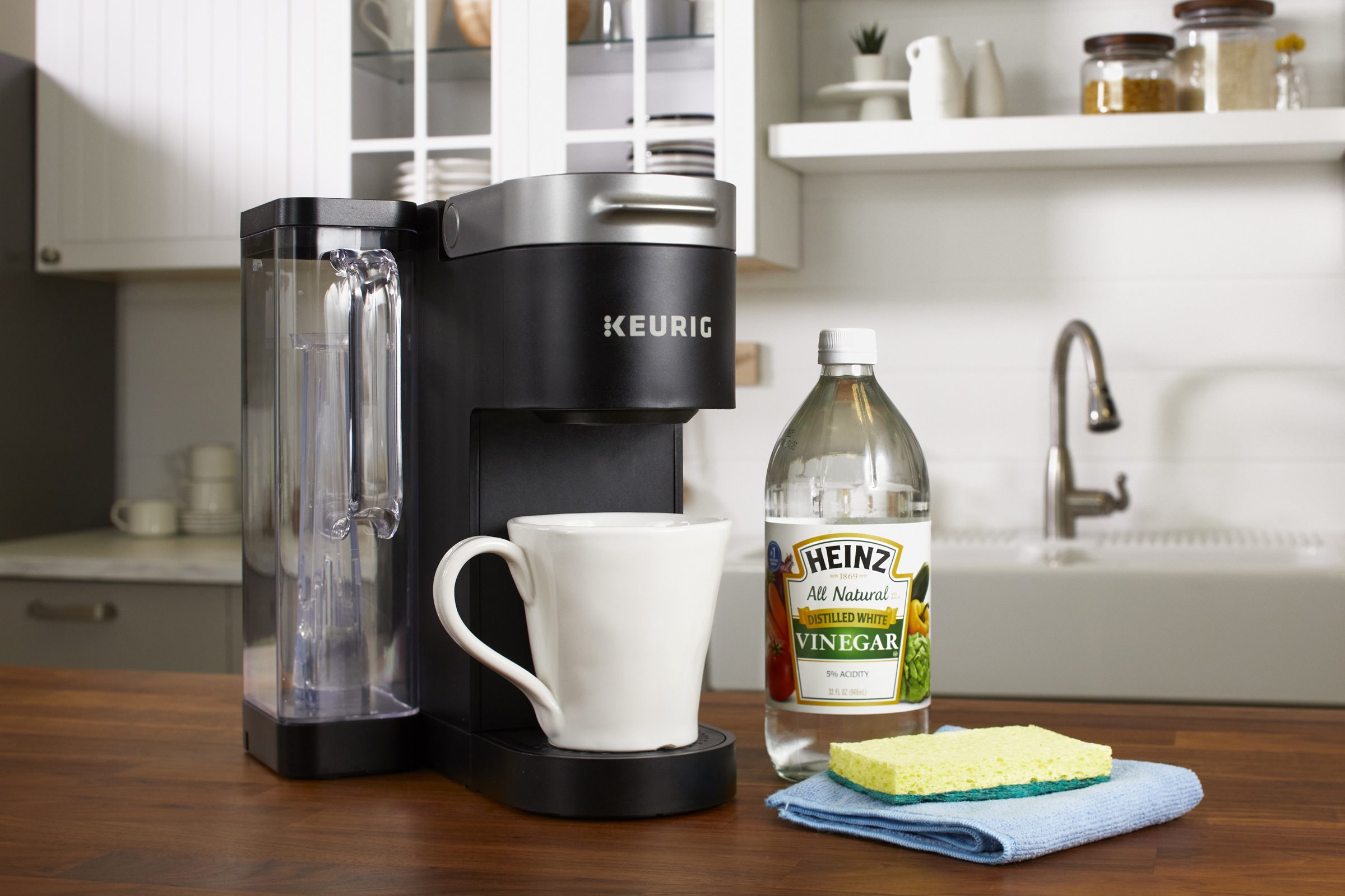https://www.rd.com/wp-content/uploads/2019/01/keurig-coffee-maker-and-cleaning-supplies-on-kitchen-counter_RDigital_HubCleaning_keurig_003.jpg?fit=700%2C1024