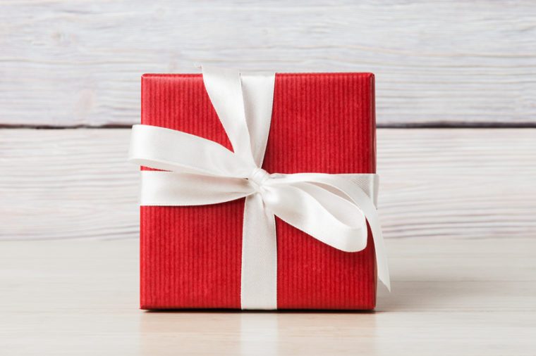 Gift box over light wooden background