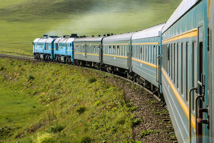 Transsiberian Railway with locomotive and steam crossing through Mongolia on a sunny summer day (near Ulaanbaatar, Mongolia, Asia)