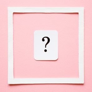 Card of question mark in white frame on pastel pink background. Soft light color. Women issues. Problem and solution concept.