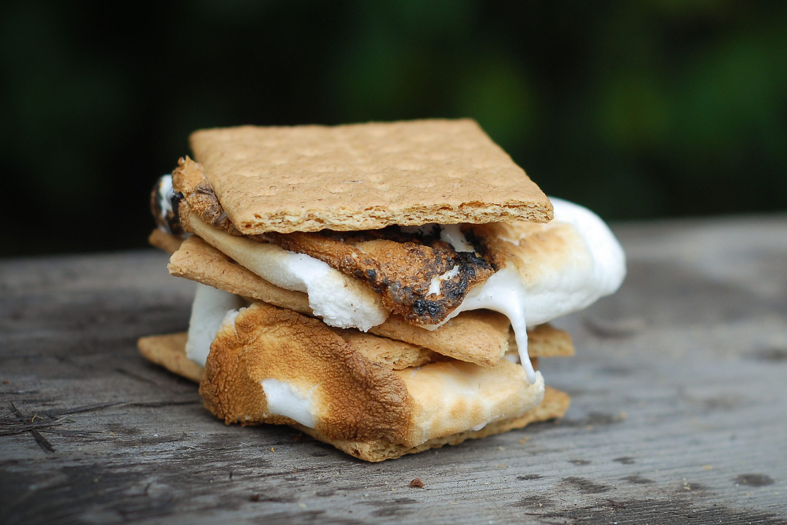 A crispy sticky double stacked smore cooked over an open fire at a summer bbq,