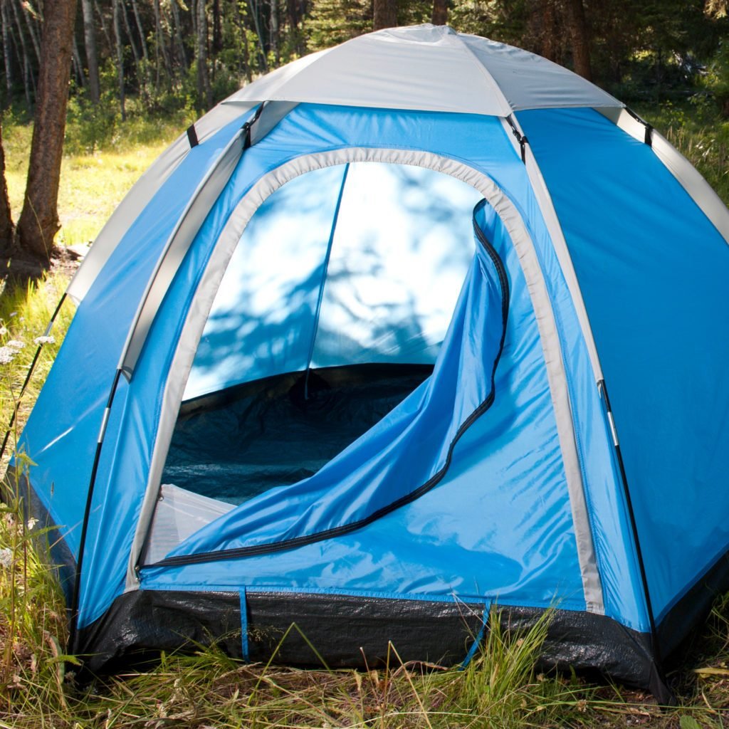 blue camping tent in the woods with door flap open