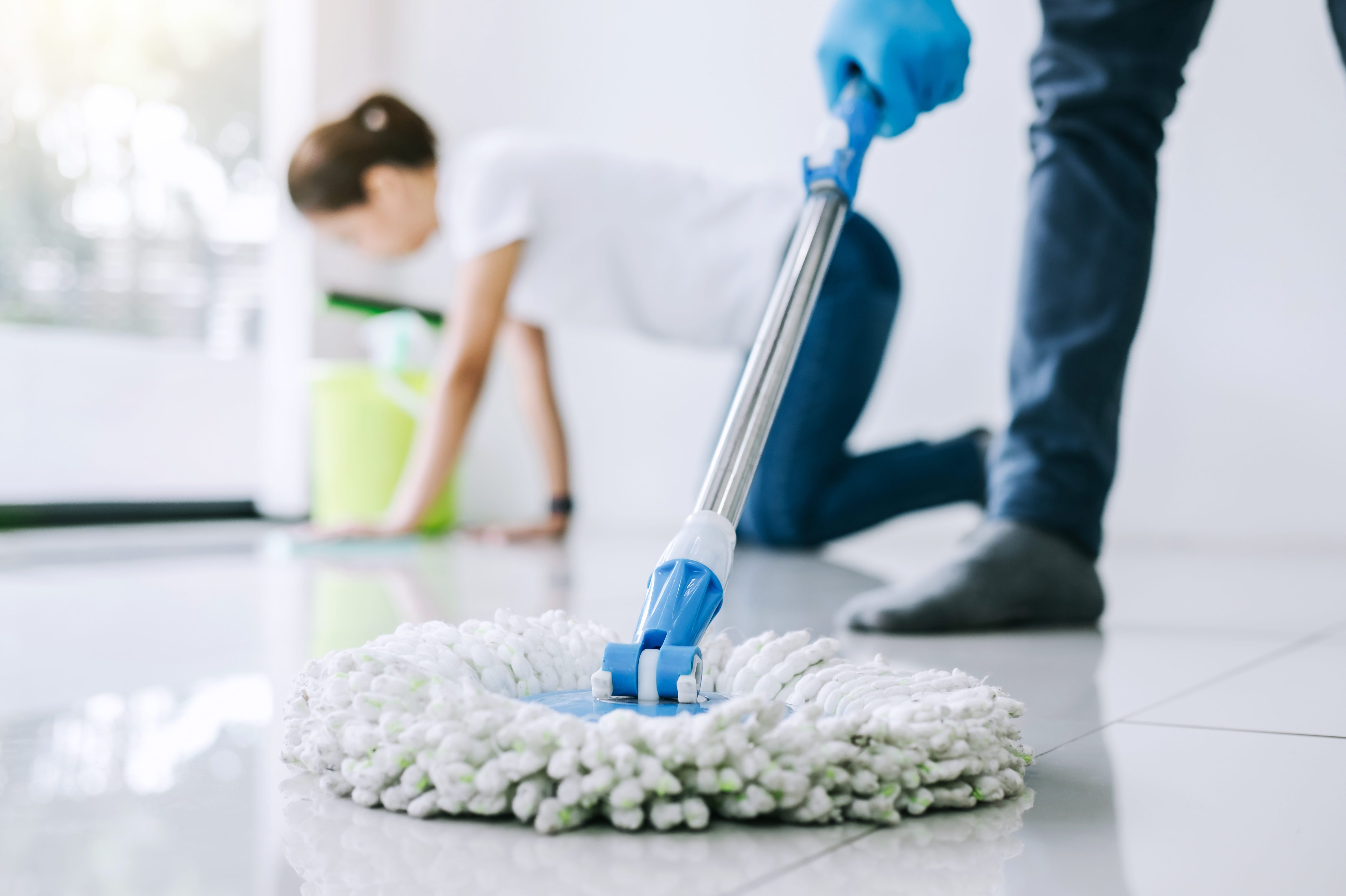 Close up man use a mop to mop the floor. Concept, household chore in daily  life. Hygienic and sanitary. Mop the dust, wipe the floor. Cleaning house.  Maintaining tile floors to be