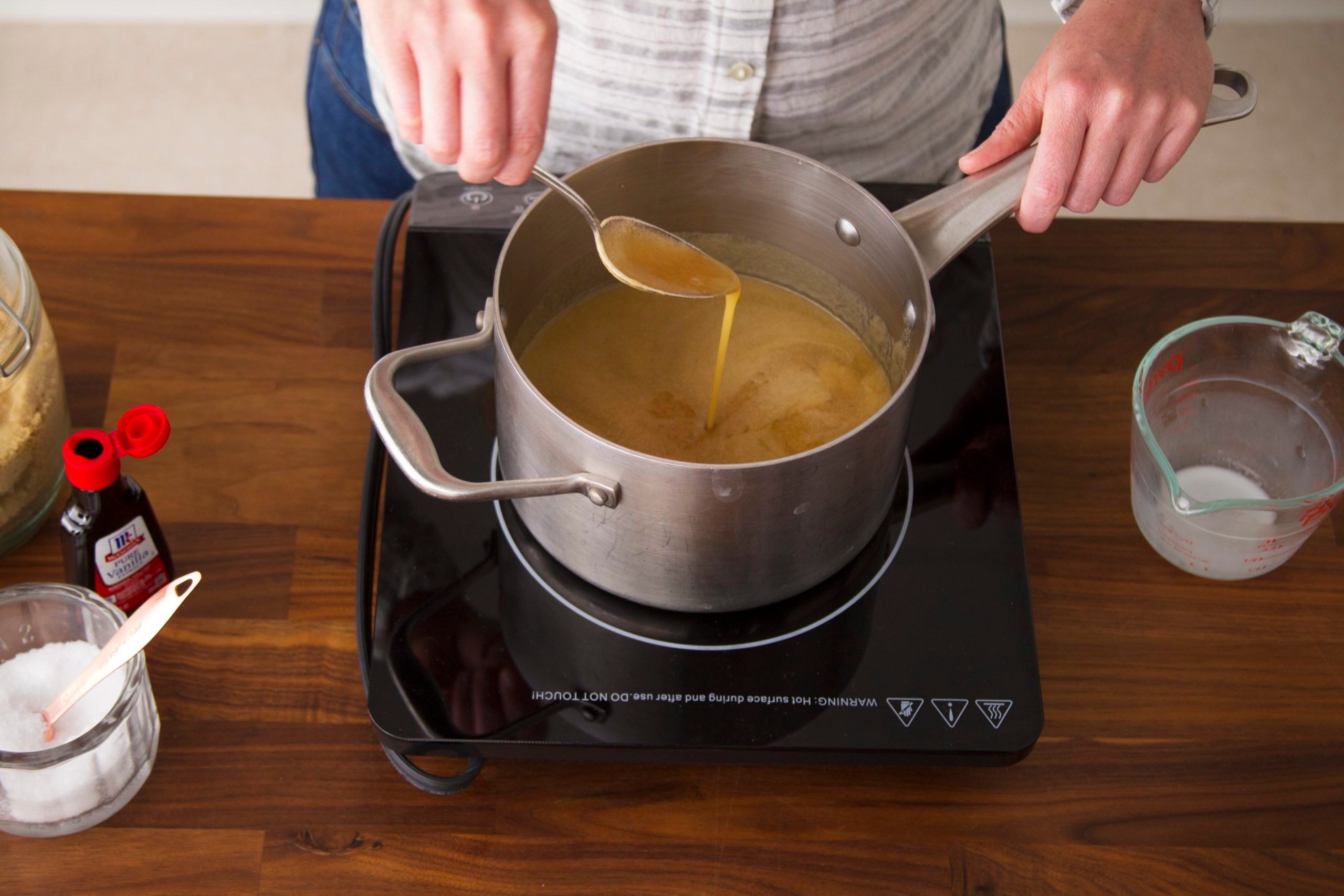 Person stirring melted butter in a saucepan on the stovetop