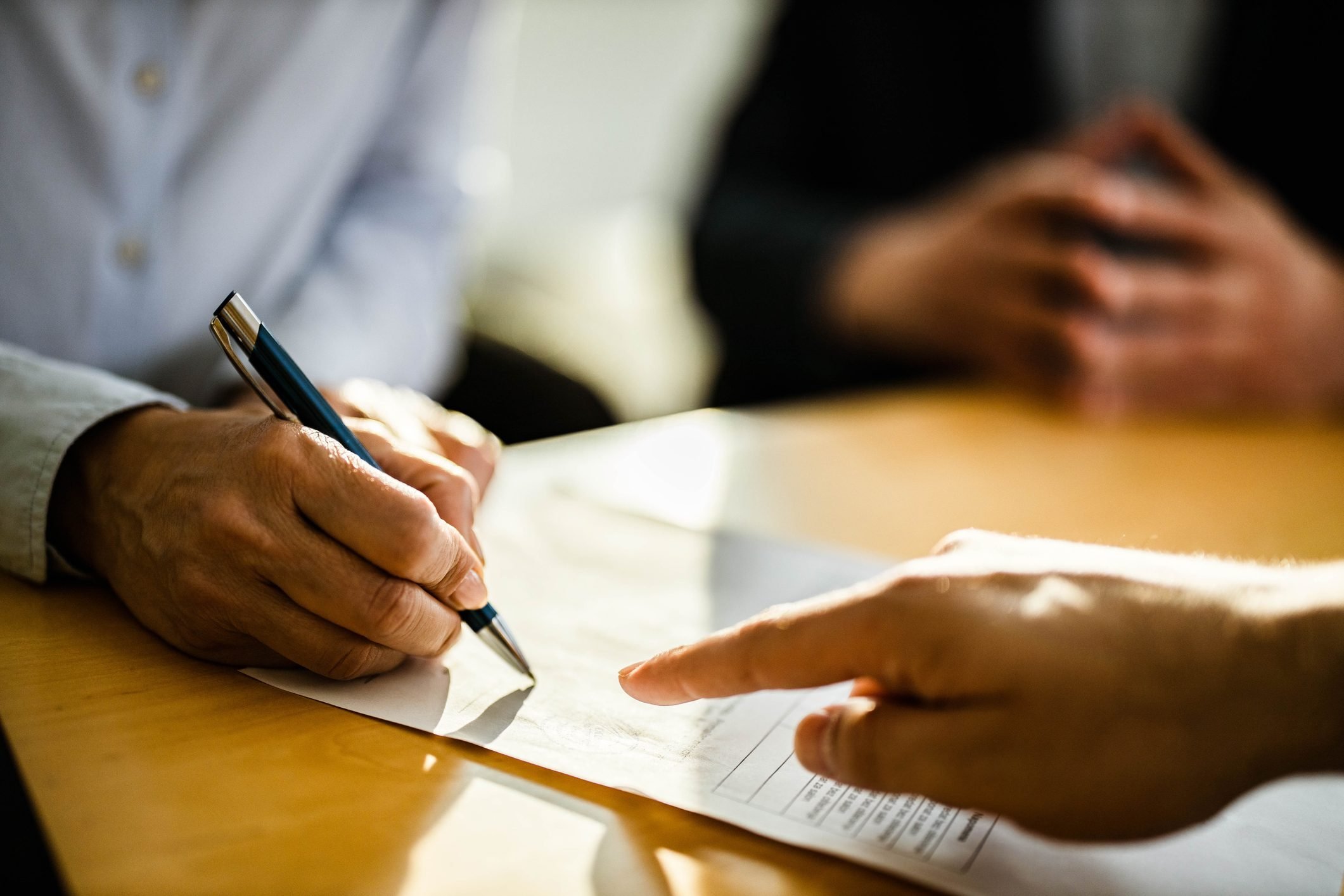 Close up of unrecognizable person signing a contract.