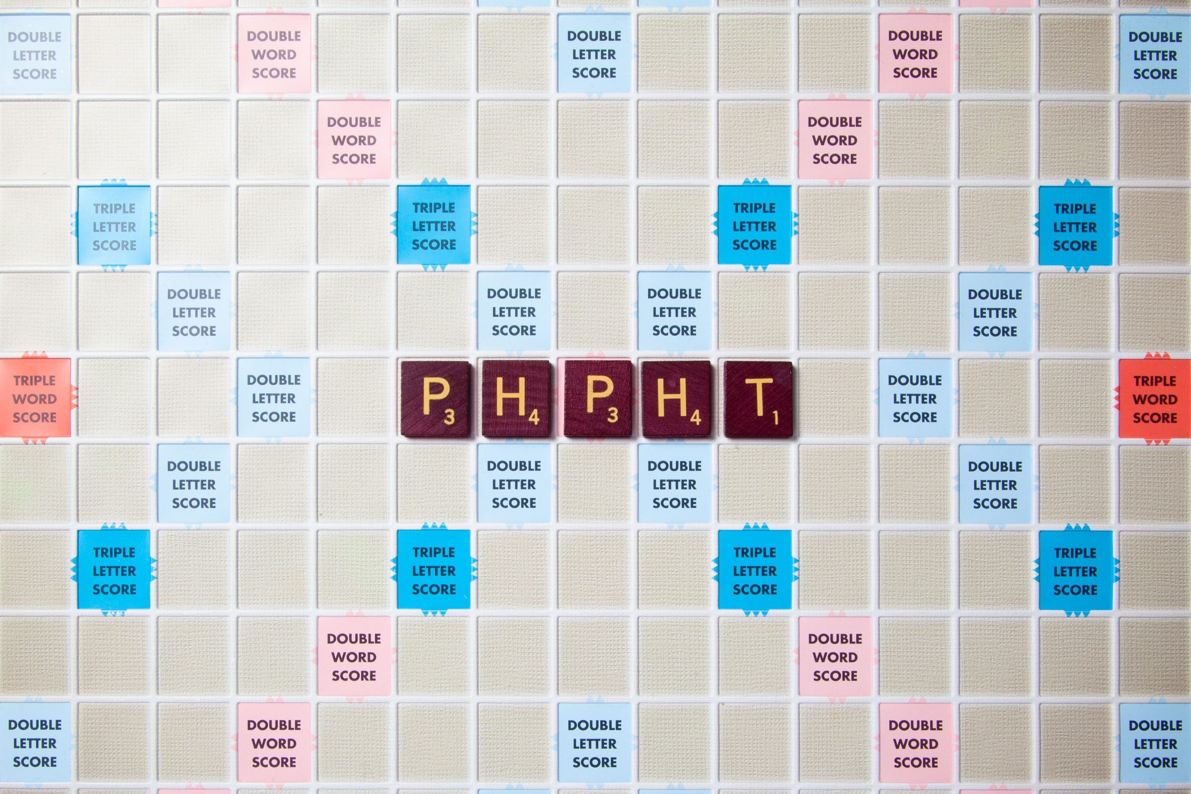 scrabble board with tiles that spell out phpht