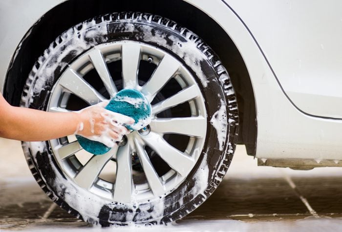 Cropped Hand Washing Tire Of Car