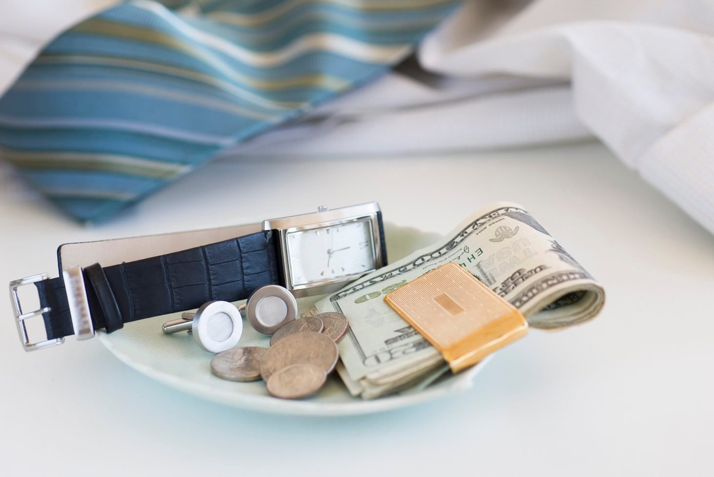 Men's items on a plate on dresser