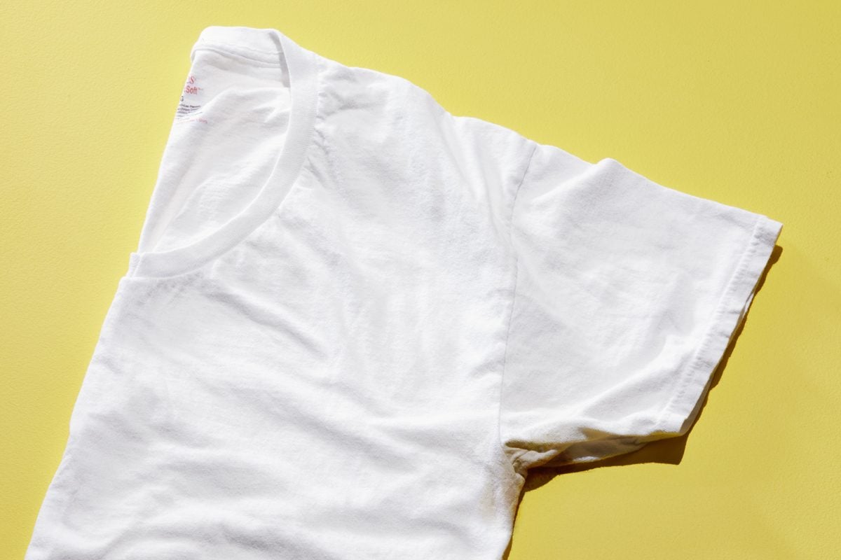 white tshirt with underarm sweat stain on a yellow background