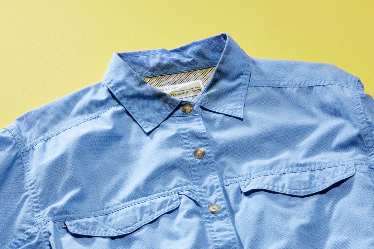 blue button down shirt with sweat stains around the inside of the collar on yellow background