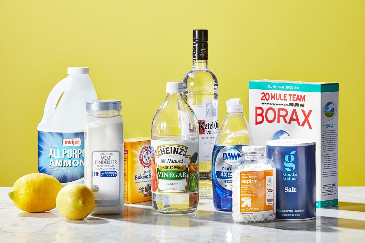 a variety of household items that may be used to remove sweat stains on a marble countertop surface against a yellow backdrop
