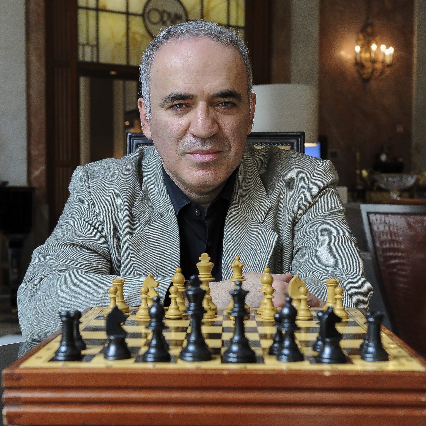 Garry Kasparov sitting with a chess board
