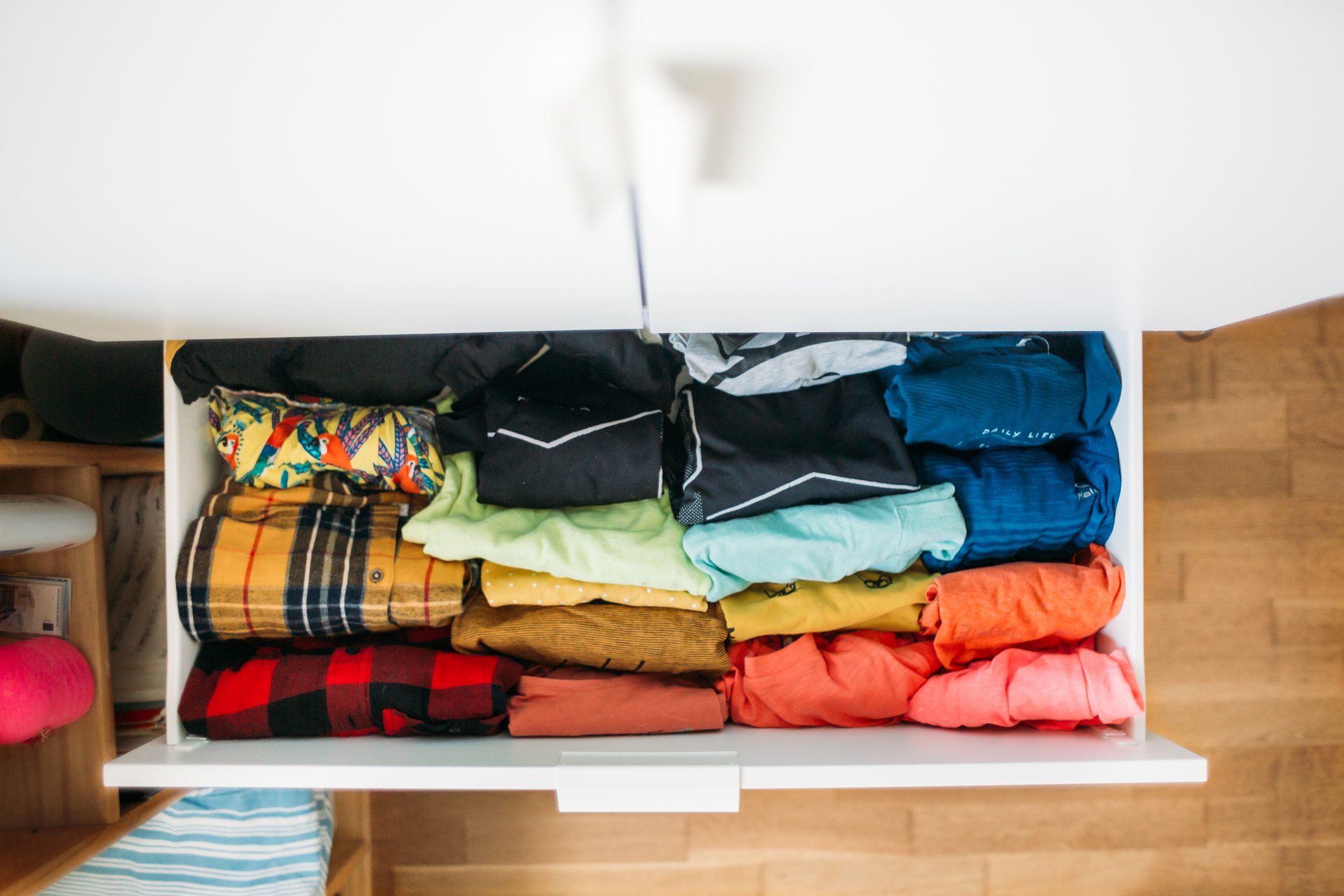 colorful shirts in a white drawer