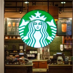 starbucks logo on exterior of glass with out of focus interior in the background inside