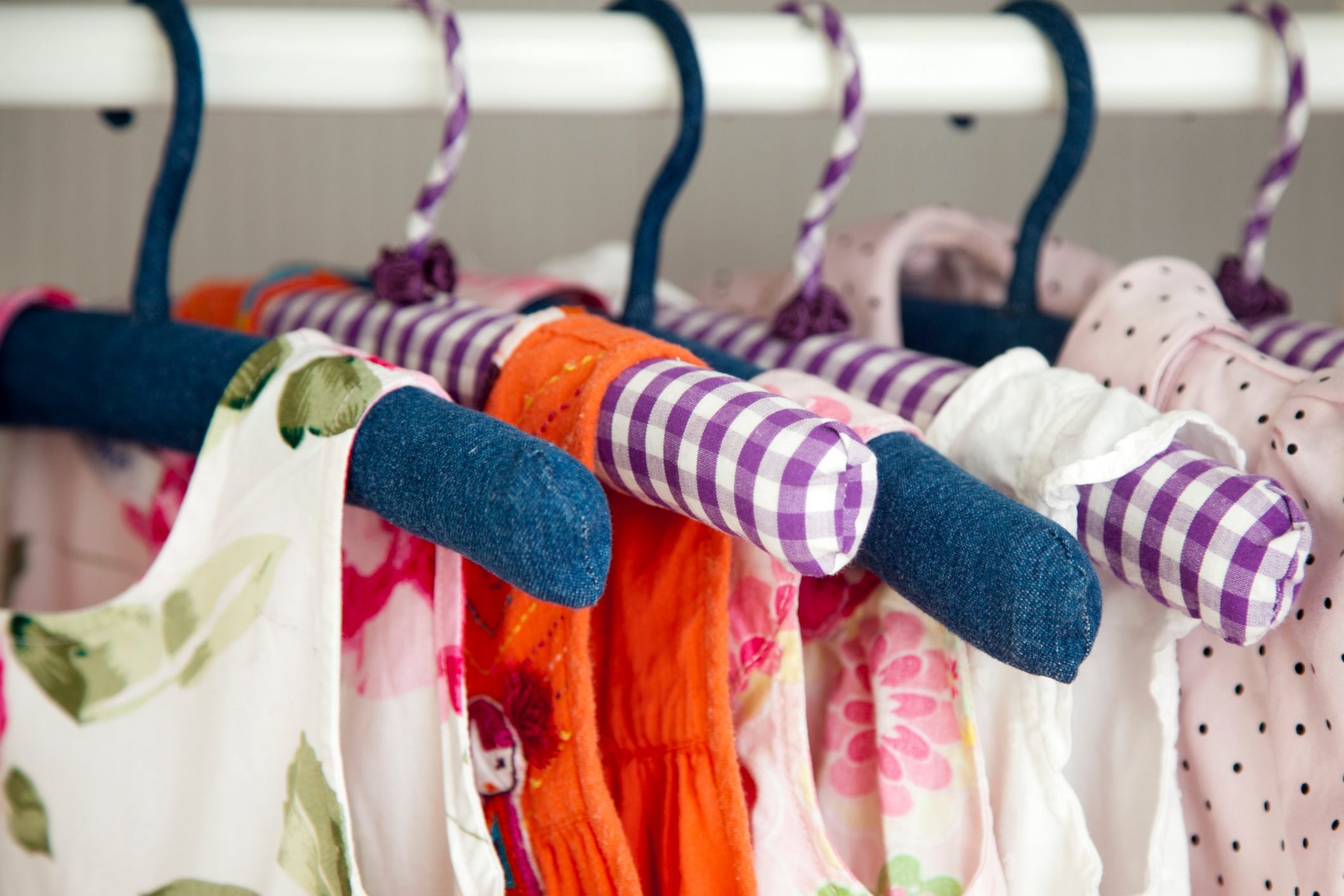 Colorful dresses hanging in wardrobe