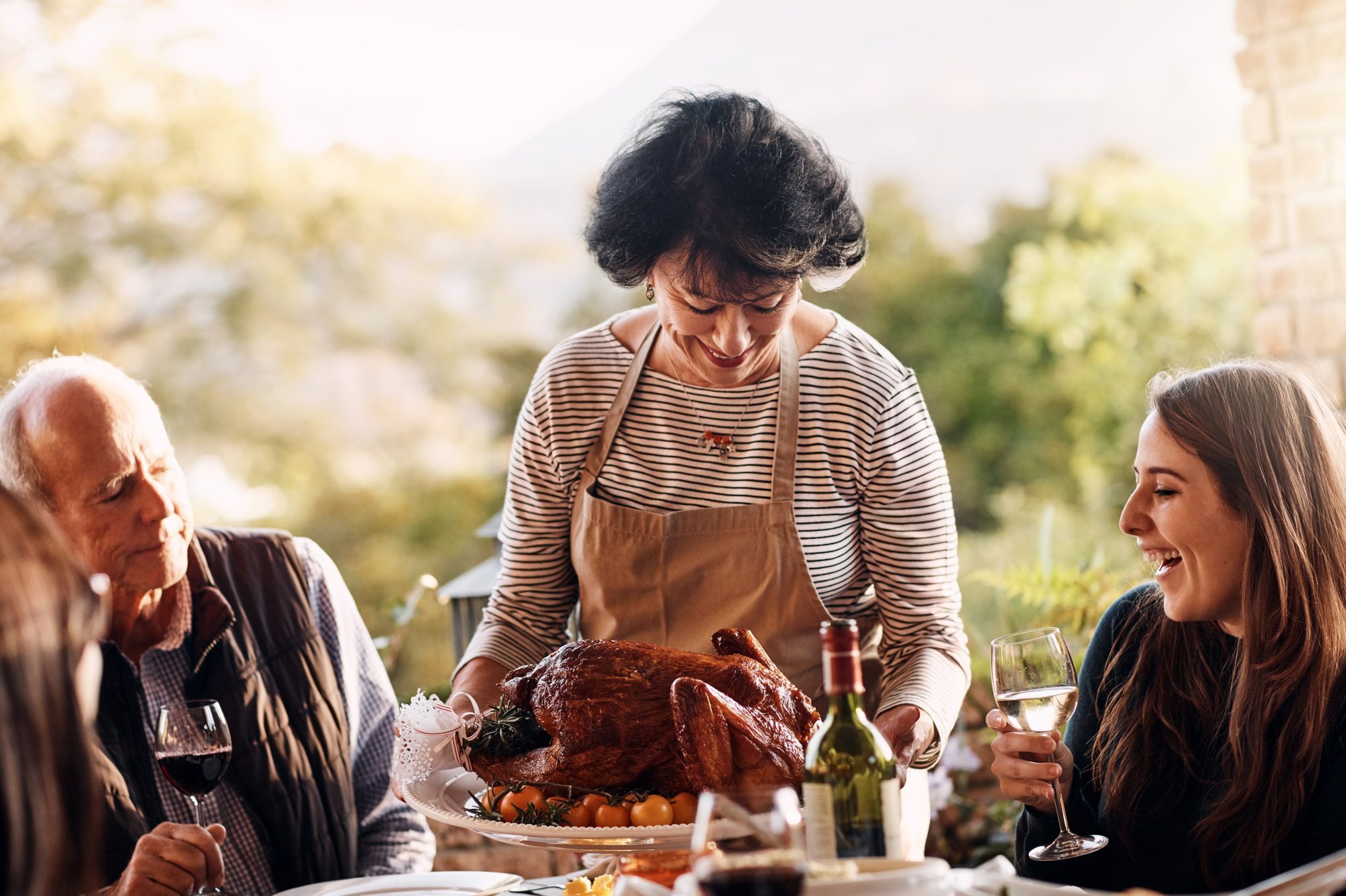 woman bringing the thanksgiving turkey to the dinner table