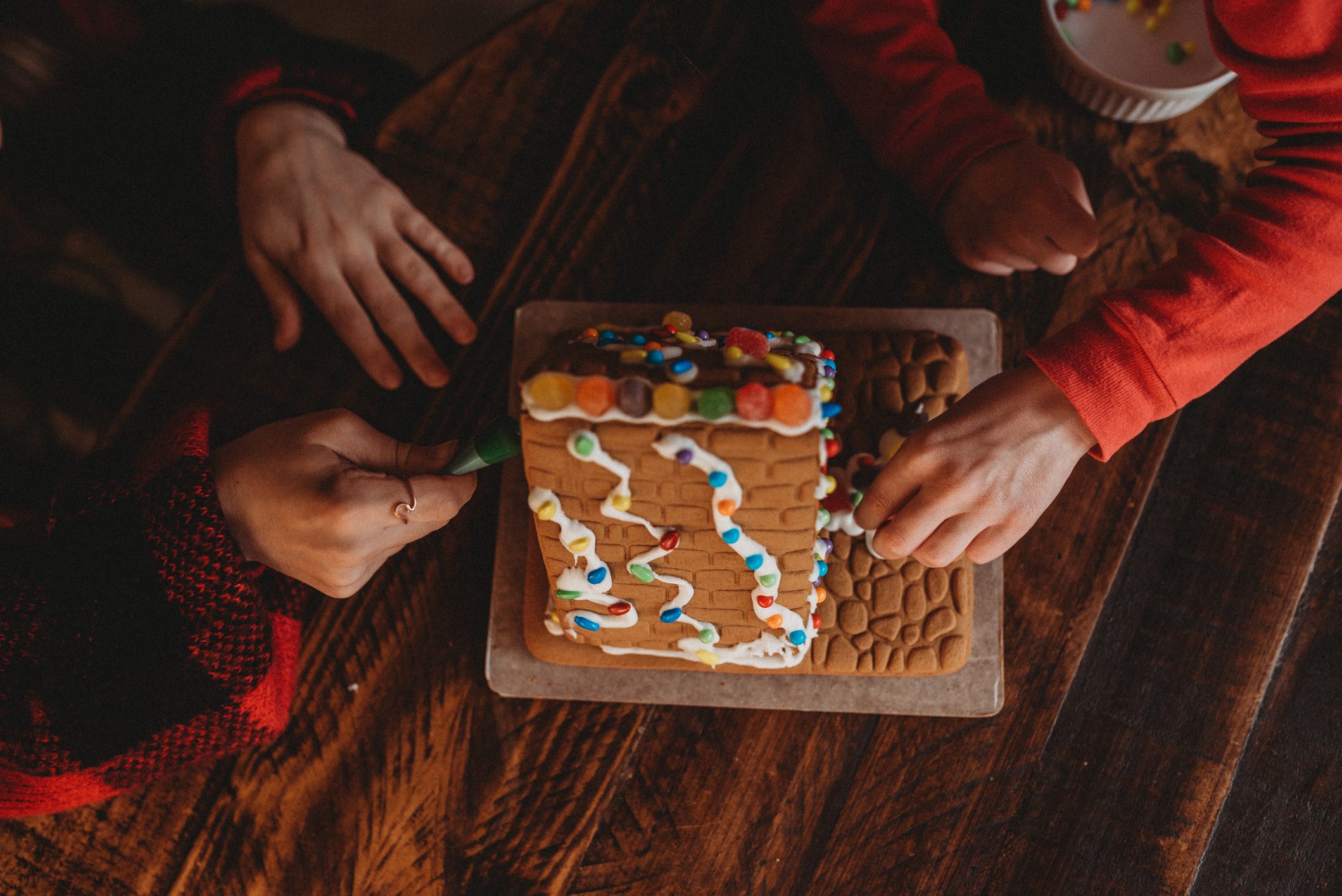 Two girls building a Gingerbread House