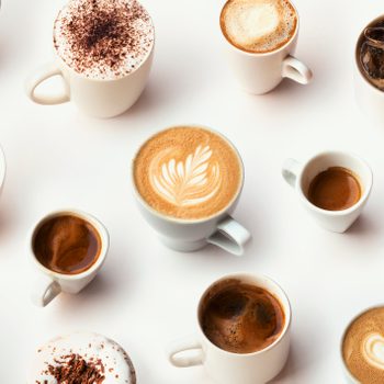 Many different types of coffee in white mugs on a white background