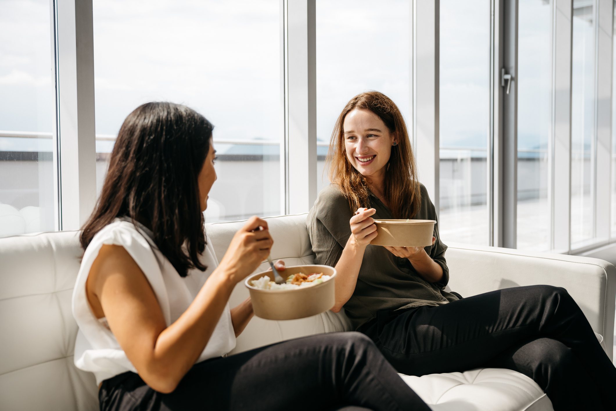 Two business women eating healthy lunch at work