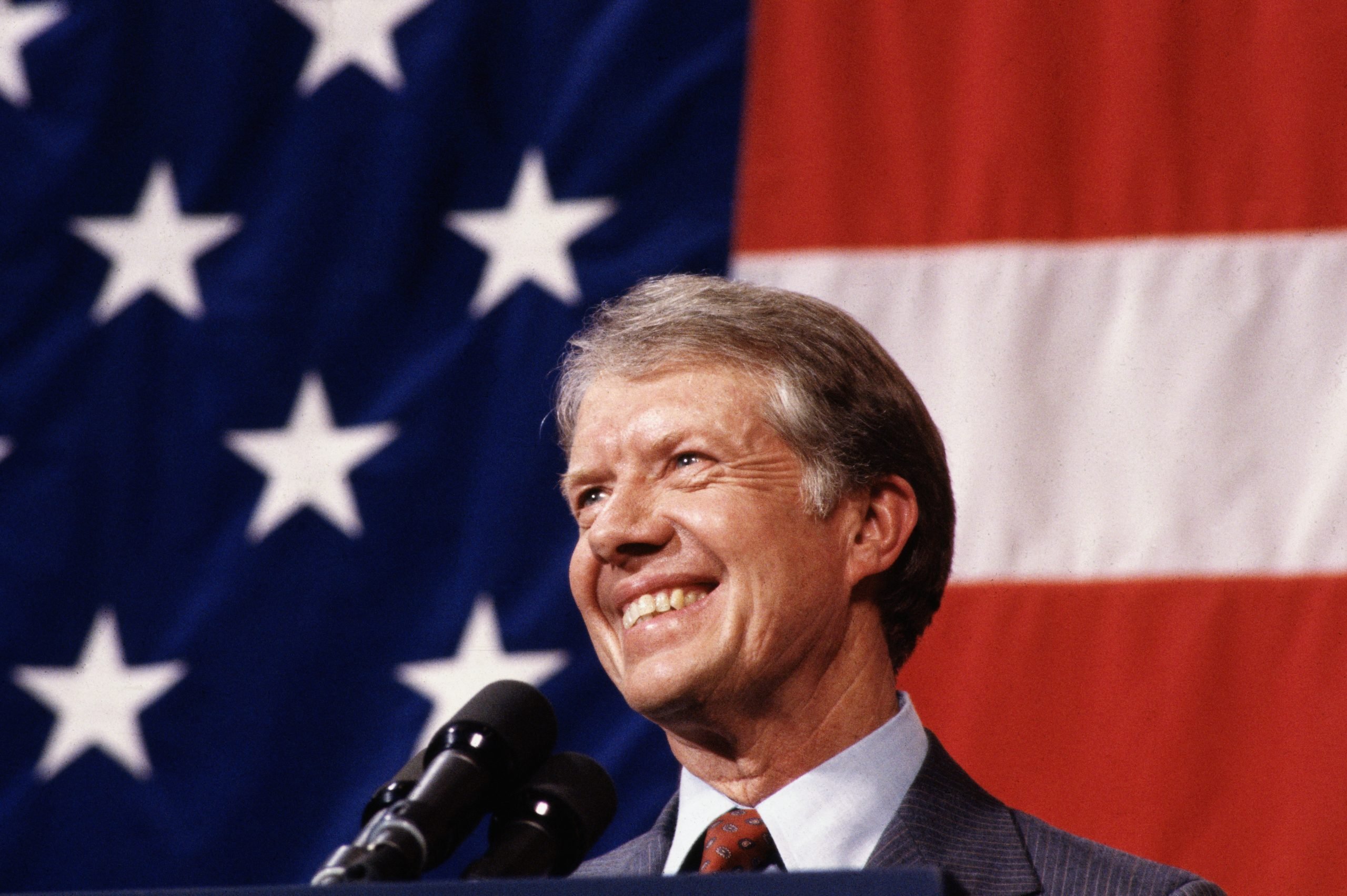 President Jimmy Carter at Podium during a town meeting with an American Flag Background