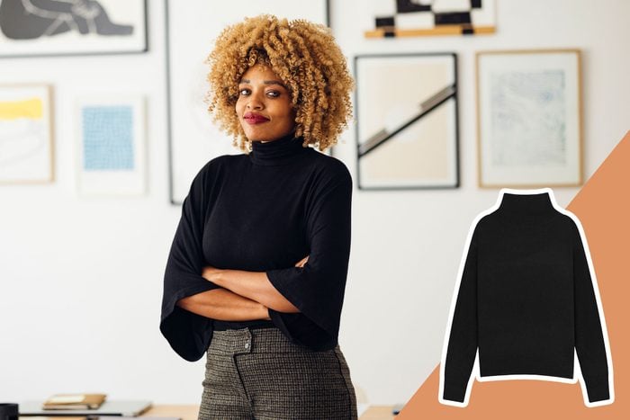 business woman in a black turtleneck standing with her arms crossed