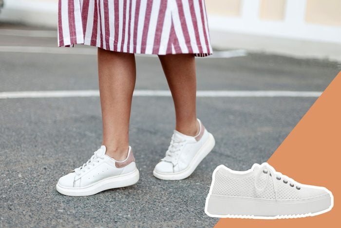 legs and white sneakers walking on pavement