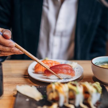 anonymous person eating sushi in a sushi restuarant